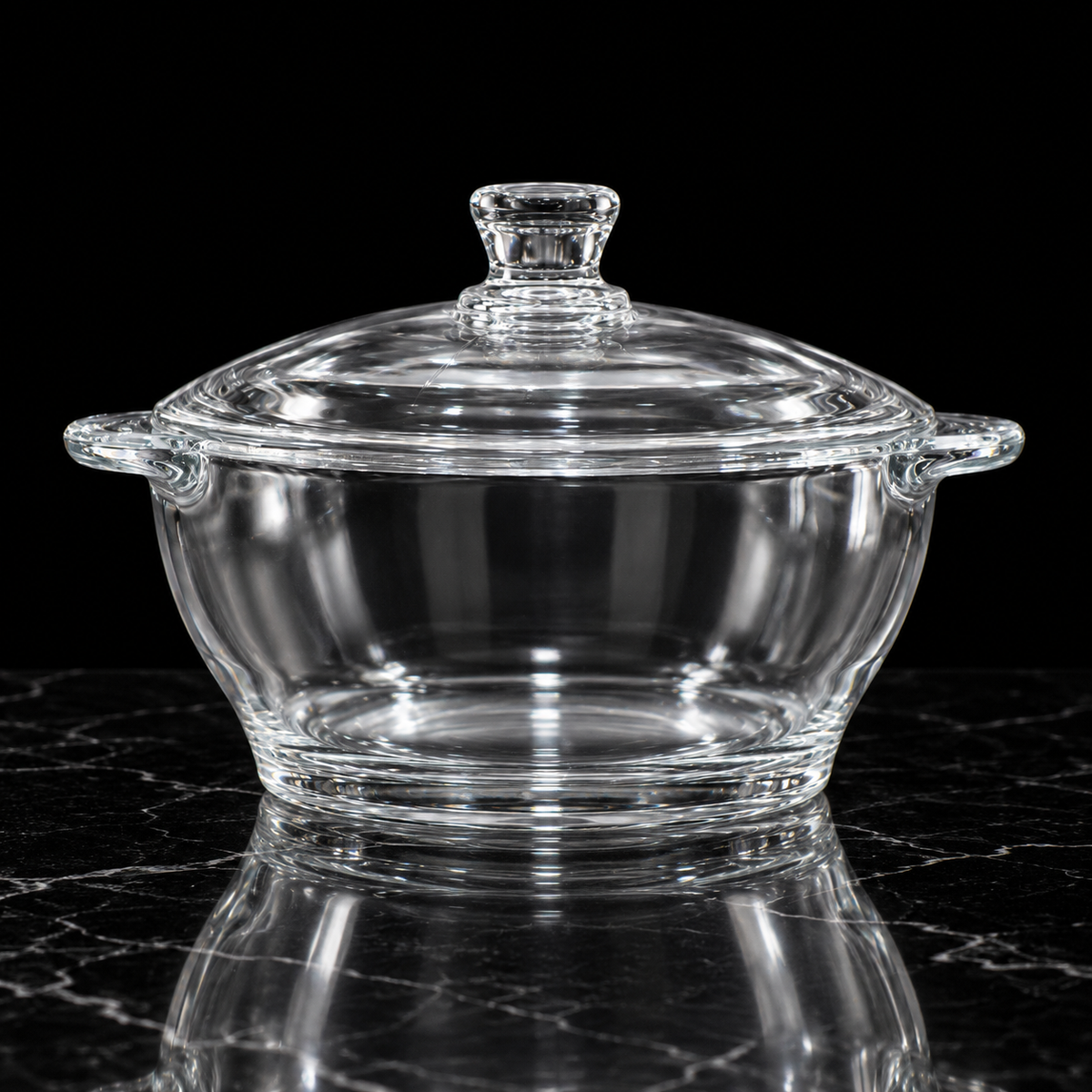 Glass casserole with lid on black marble