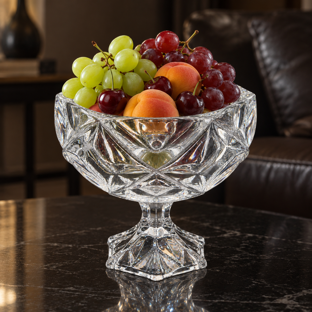 Crystal footed bowl with grapes, apricots and cherries on a black table