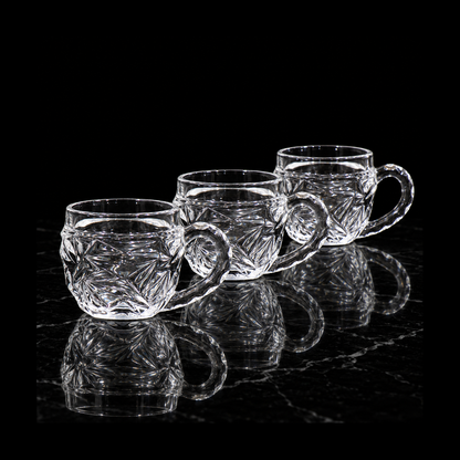 Starburst-cut glass tea cups on black marble