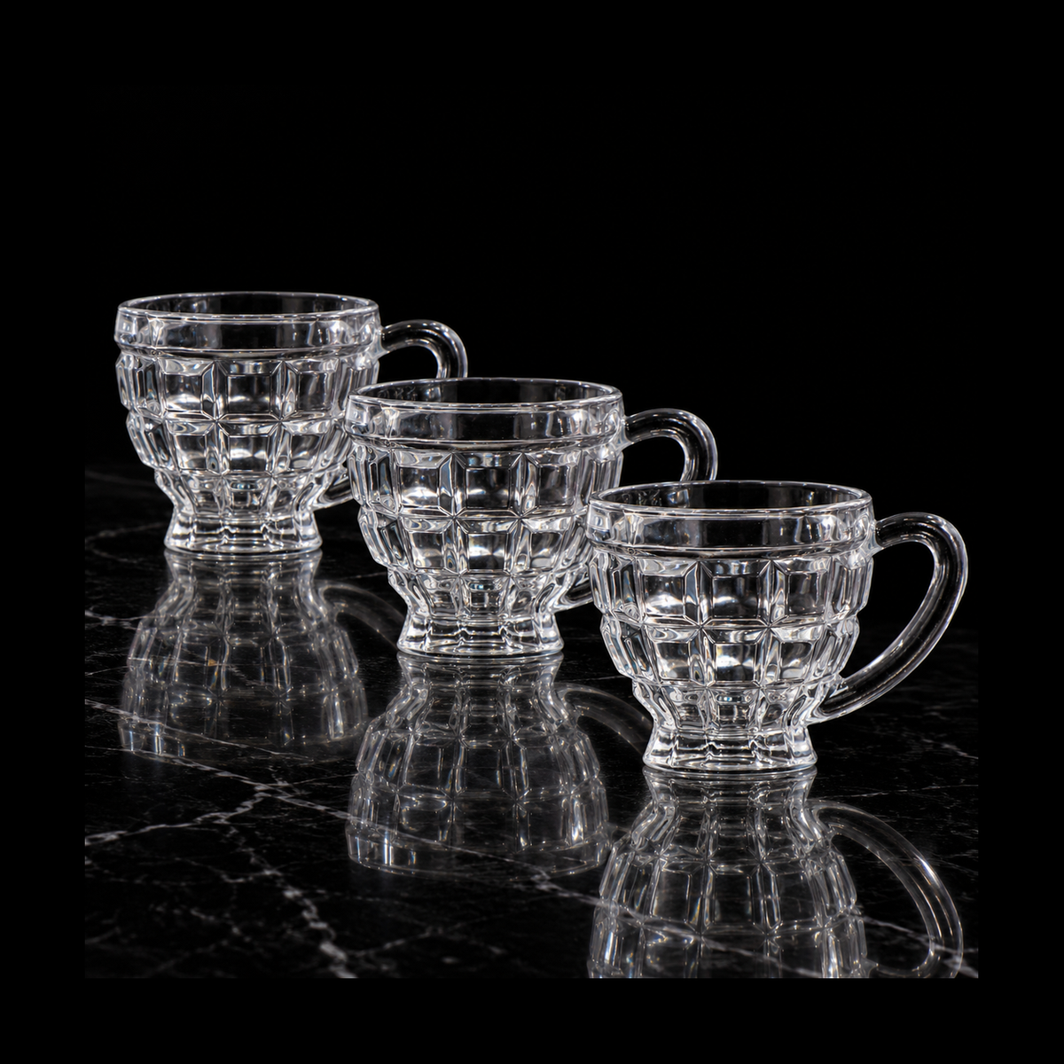 Block-cut glass tea cups on black marble