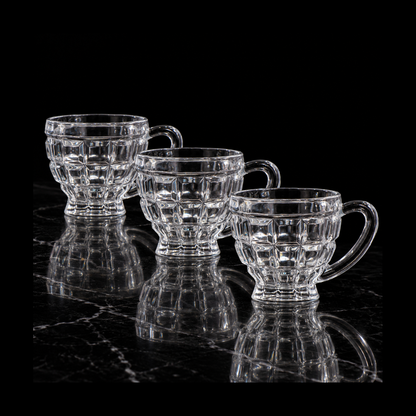 Block-cut glass tea cups on black marble