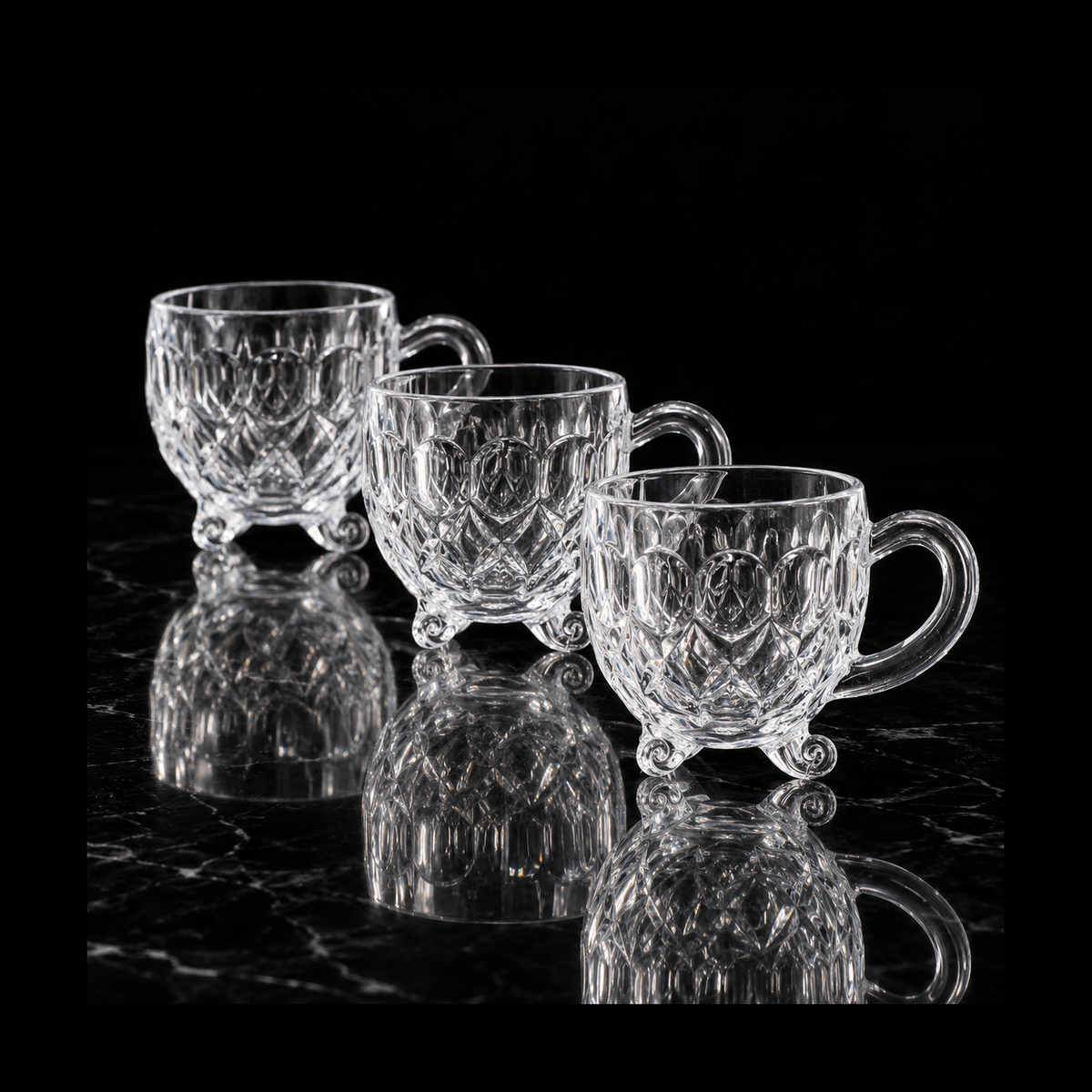 Footed glass tea cups on black marble