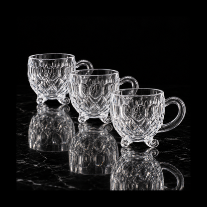 Footed glass tea cups on black marble