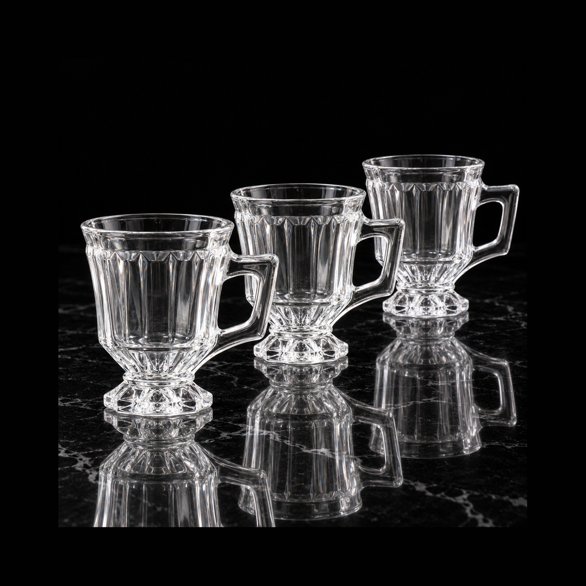 Pedestal glass tea cups on black marble