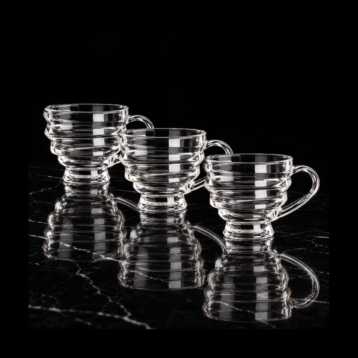Wave-ring glass tea cups on black marble