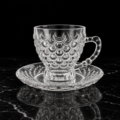Fish scale glass tea cup and saucer on black marble