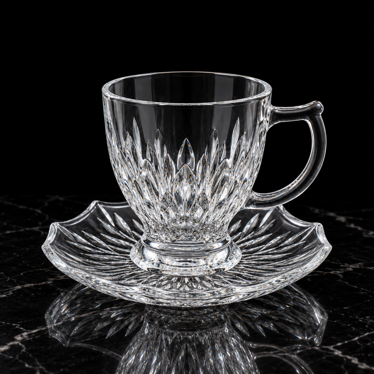 Leaf cut glass tea cup and saucer on black marble