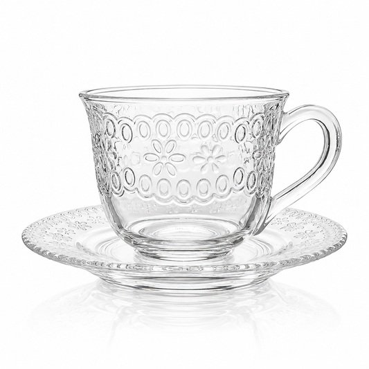 Embossed floral glass tea cup and saucer on white