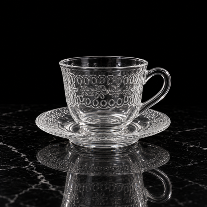 Embossed floral glass tea cup and saucer on black marble