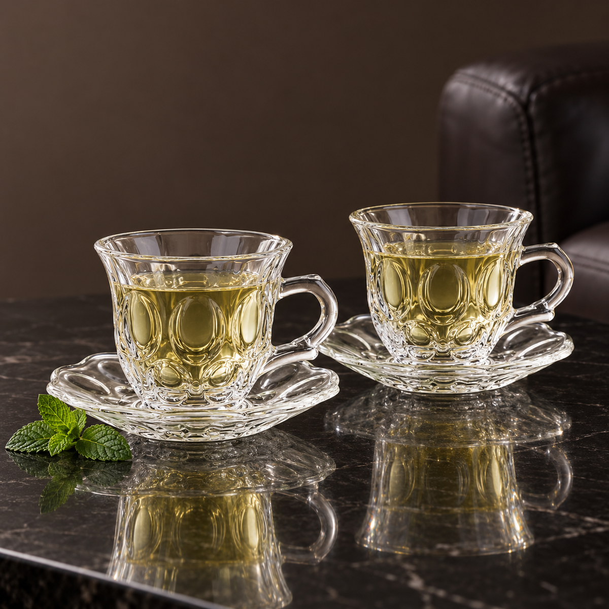 Two glass tea cups with green tea in a living room
