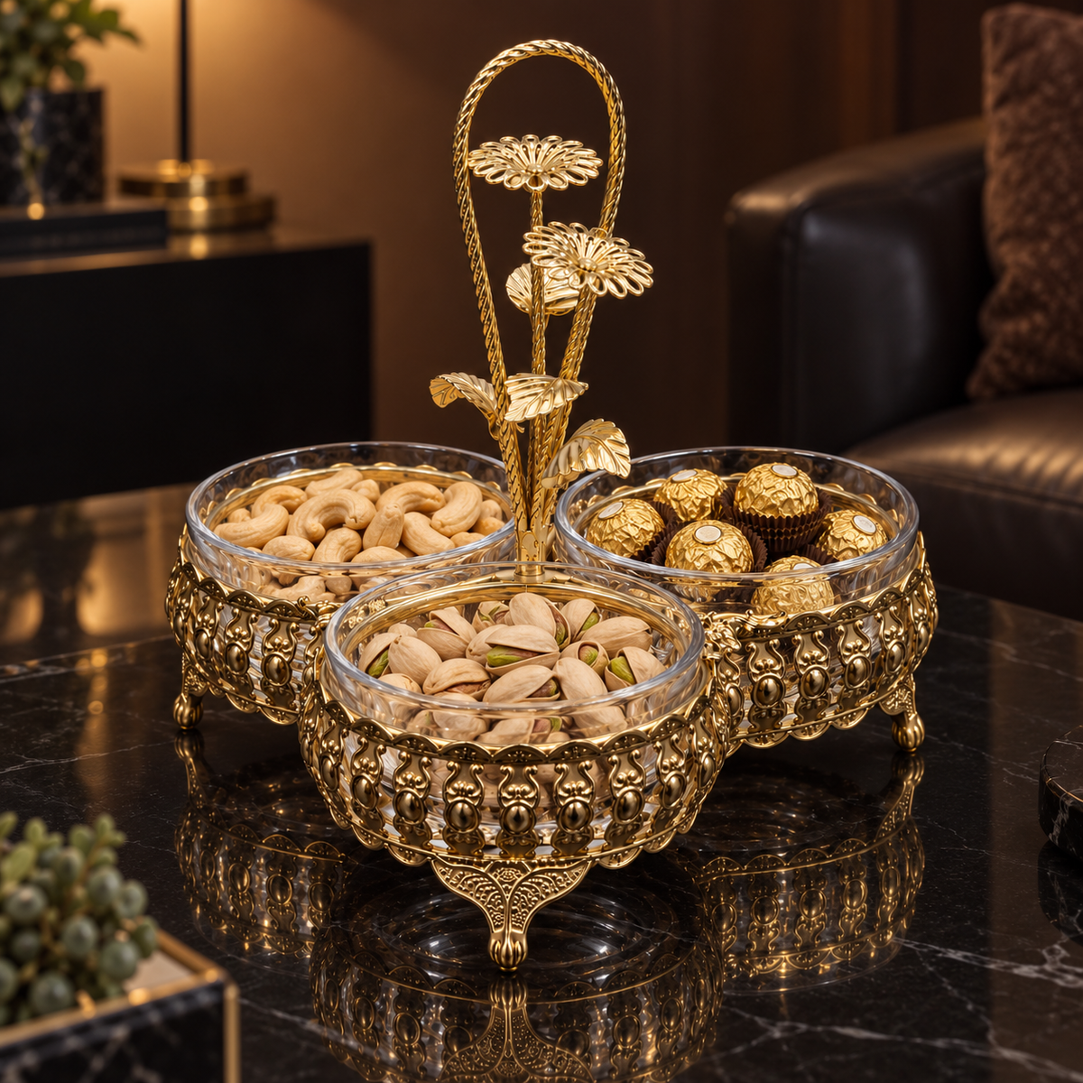 Gold triple dish with nuts and chocolates on a black table