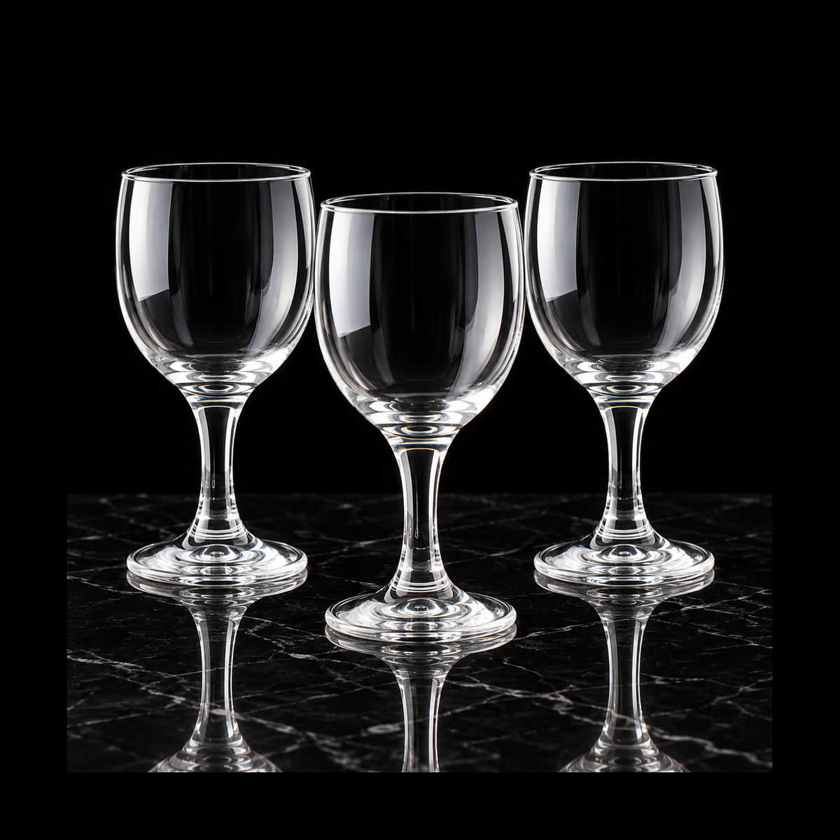 Clear wine goblets on black marble