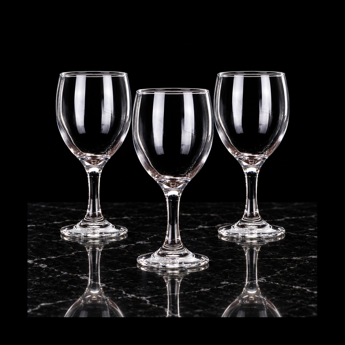Clear wine goblets on black marble