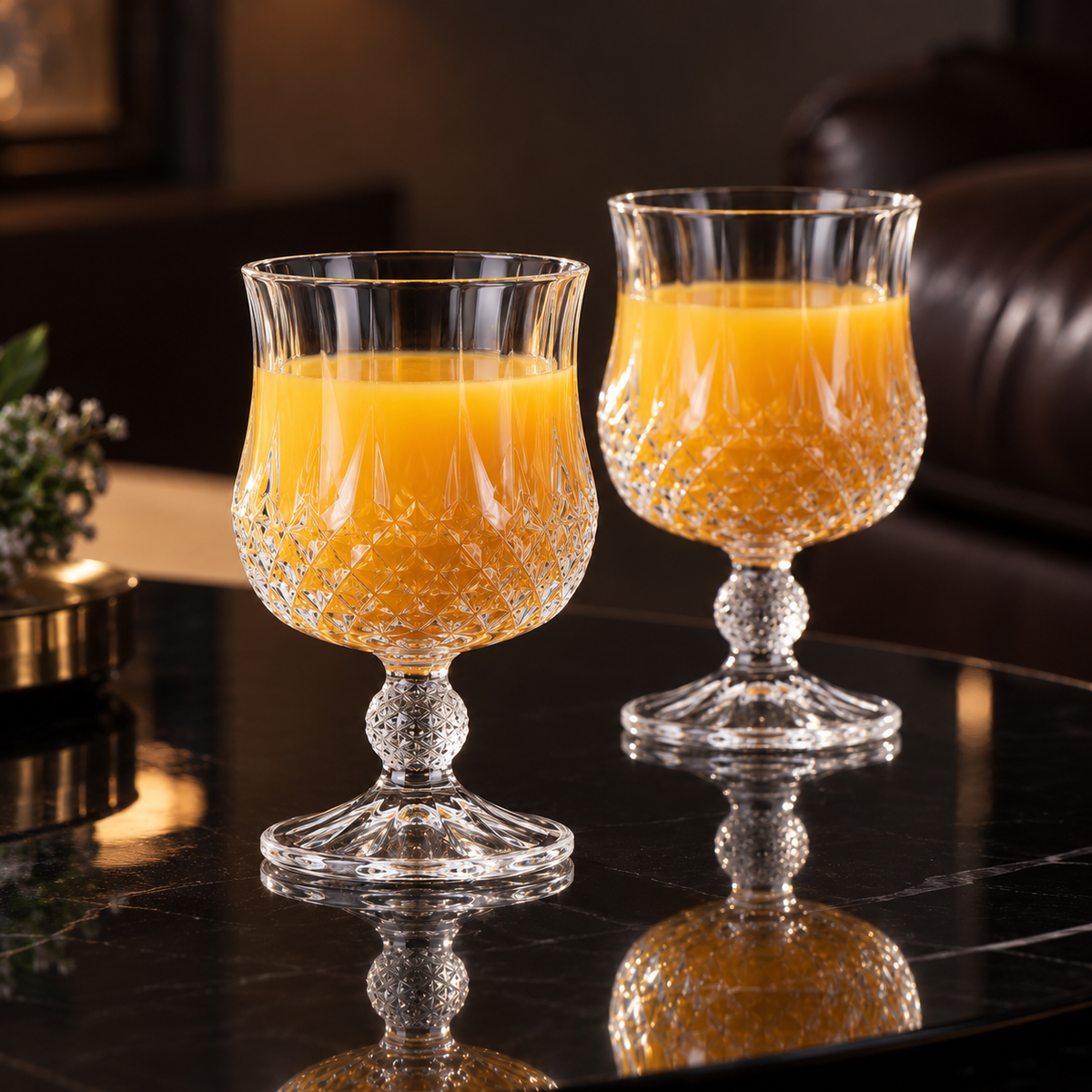 Crystal goblets with orange juice in living room