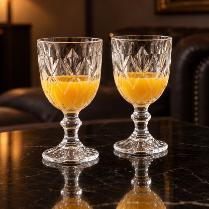 Cut crystal goblets with mango juice in a living room