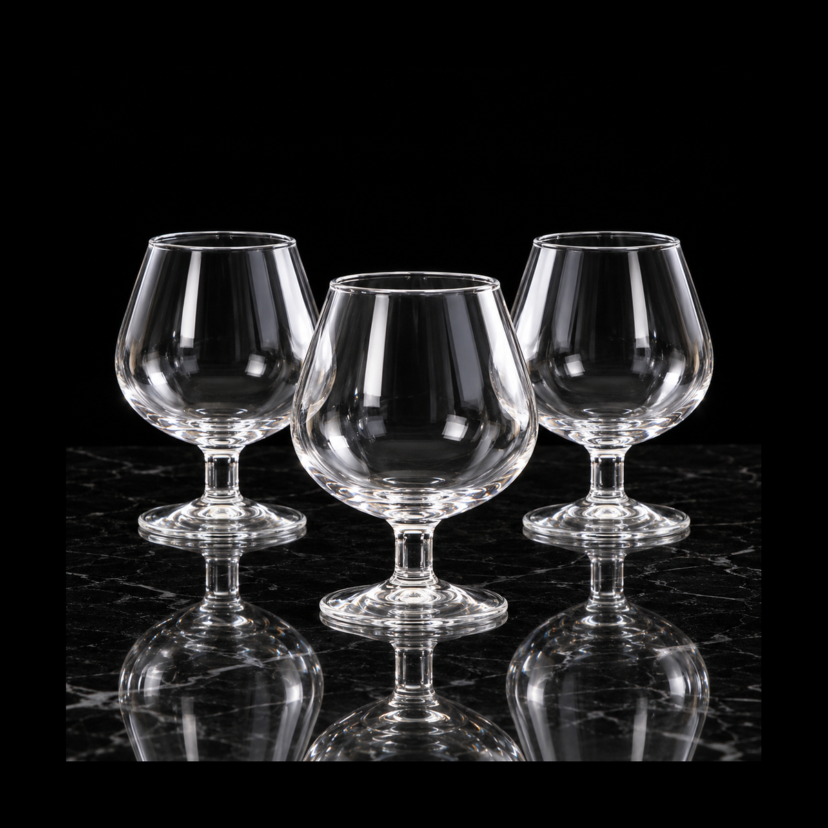 Clear glass snifters on black marble
