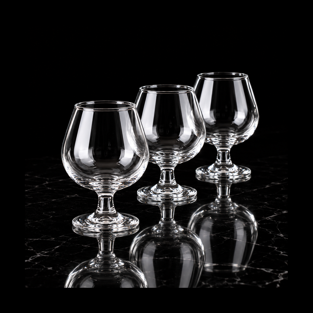 Clear snifter glasses on black marble