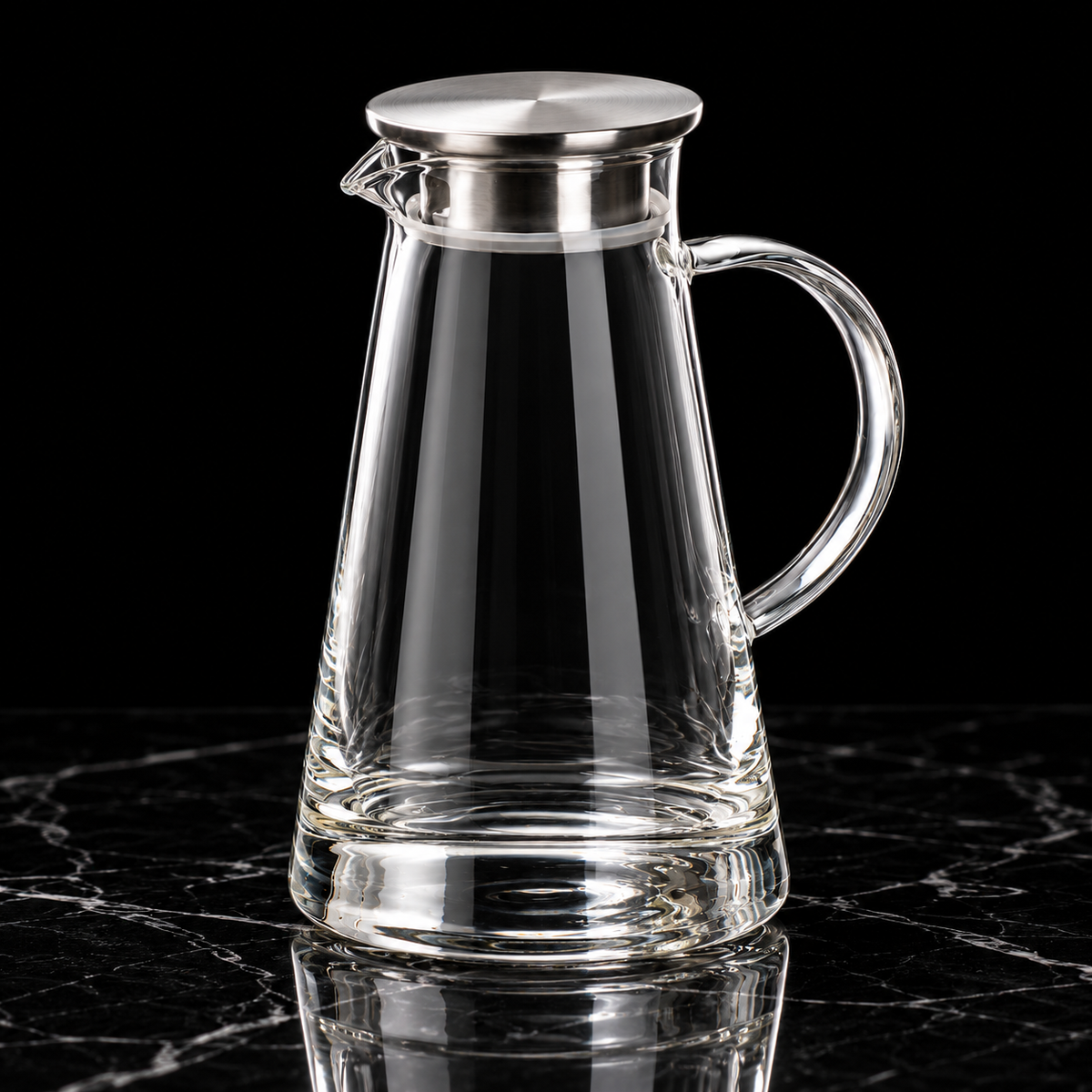 Glass water jug with steel lid on black marble