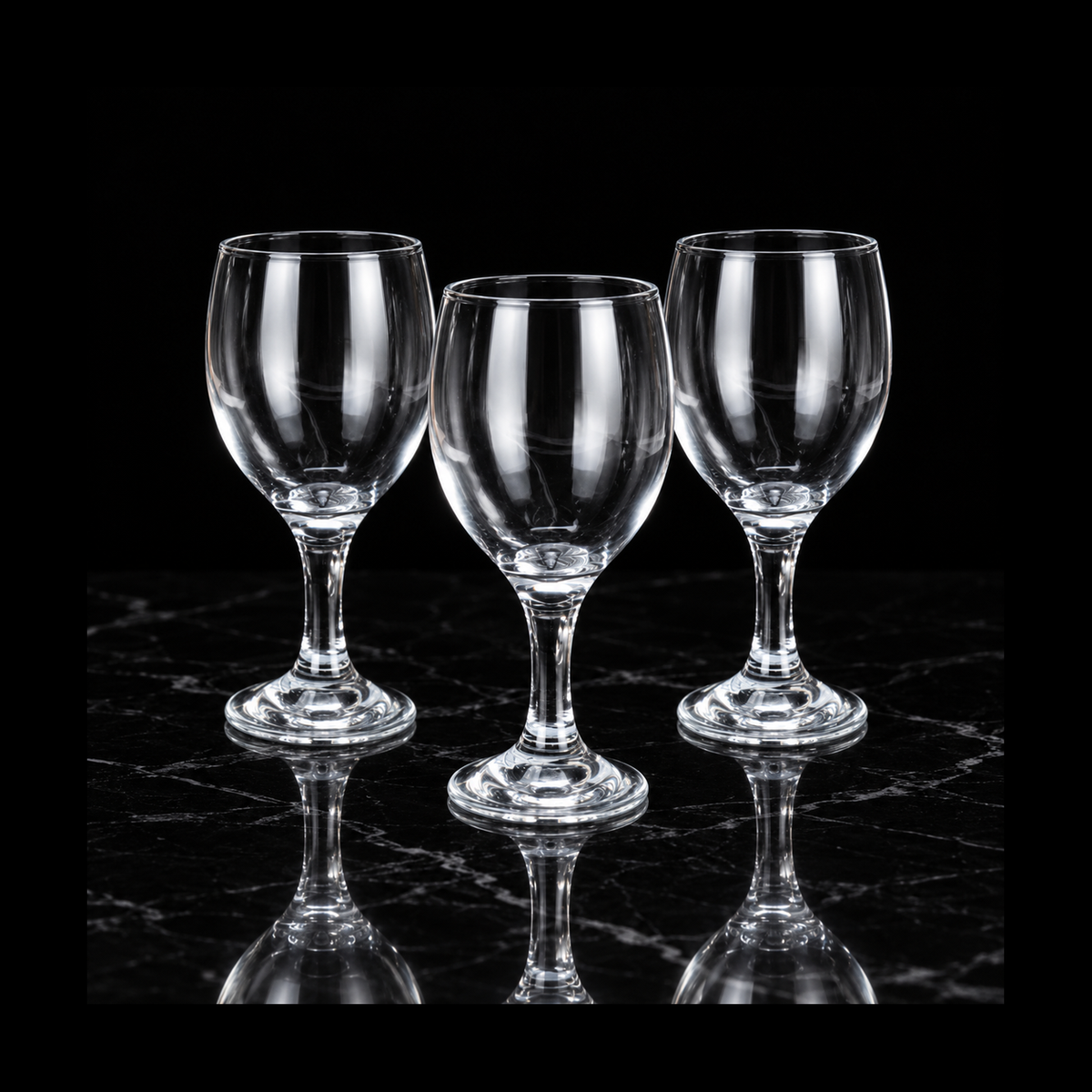 Clear wine goblets on black marble