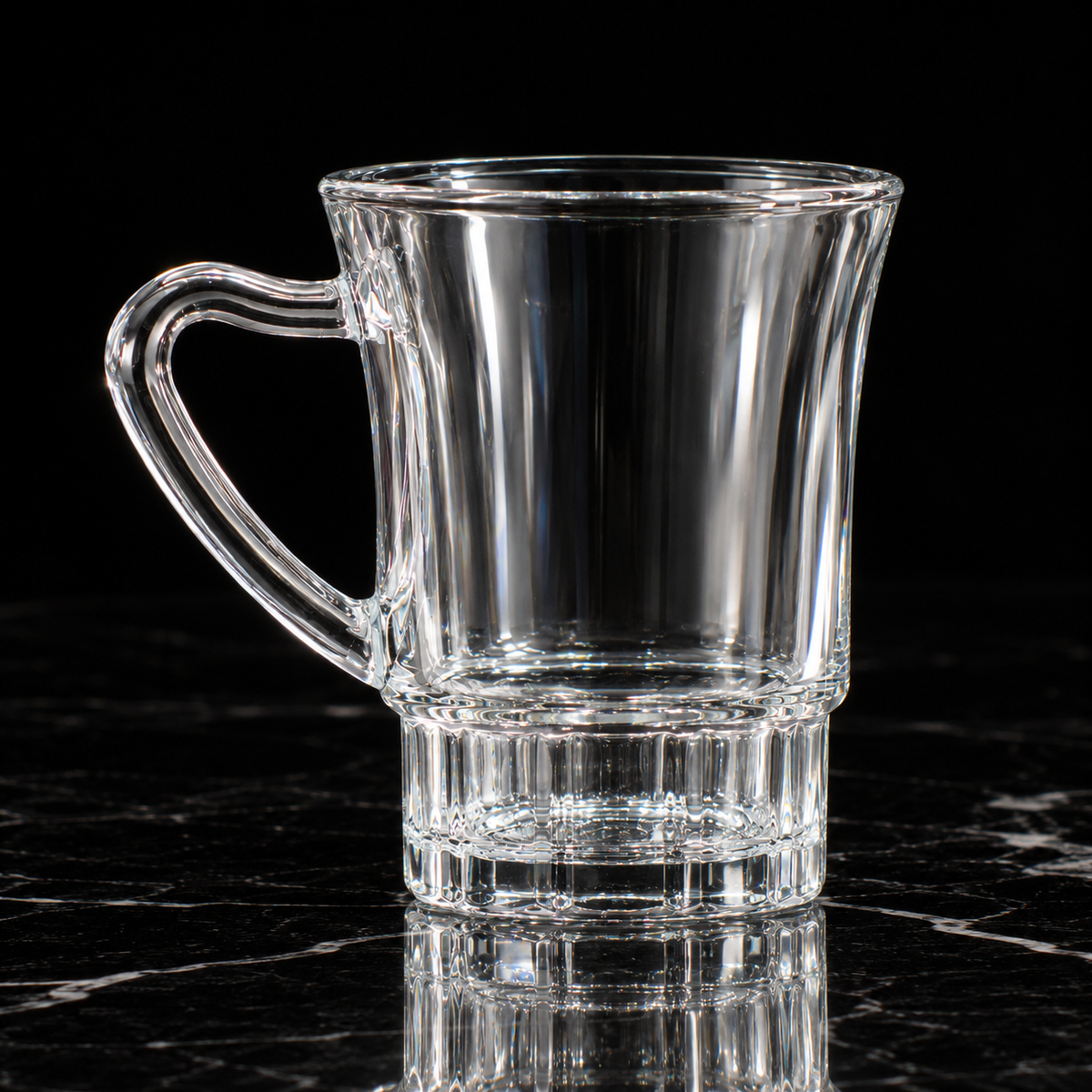 Glass mug with ribbed base on black marble