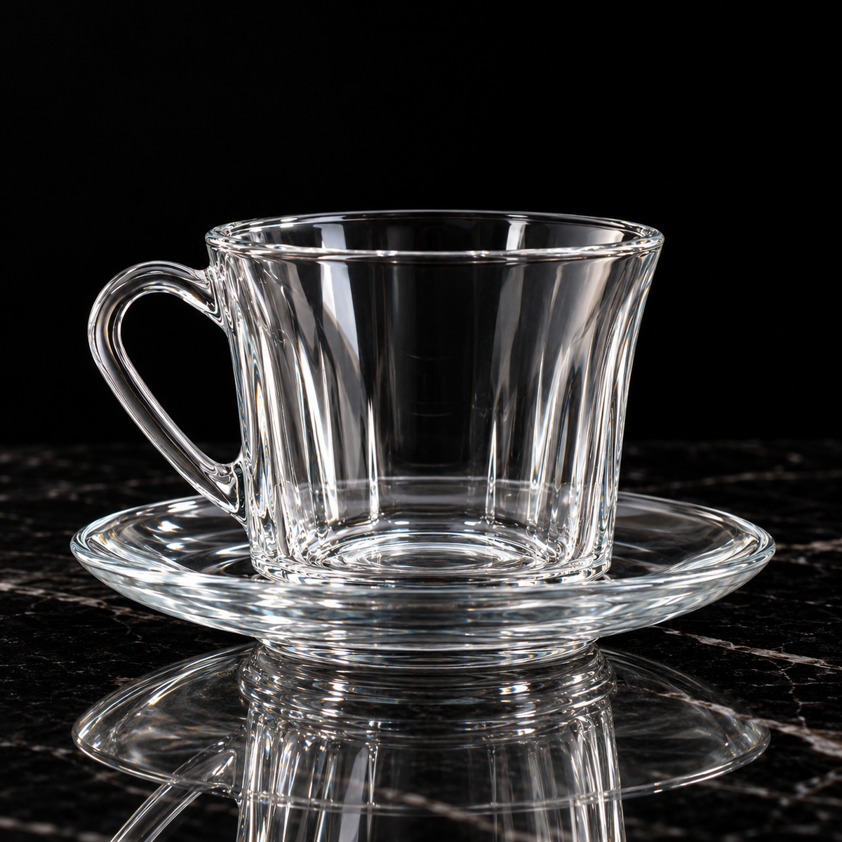 Glass tea cup and saucer on black marble