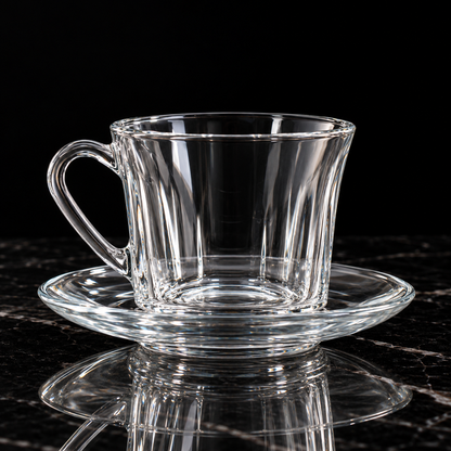 Glass tea cup and saucer on black marble