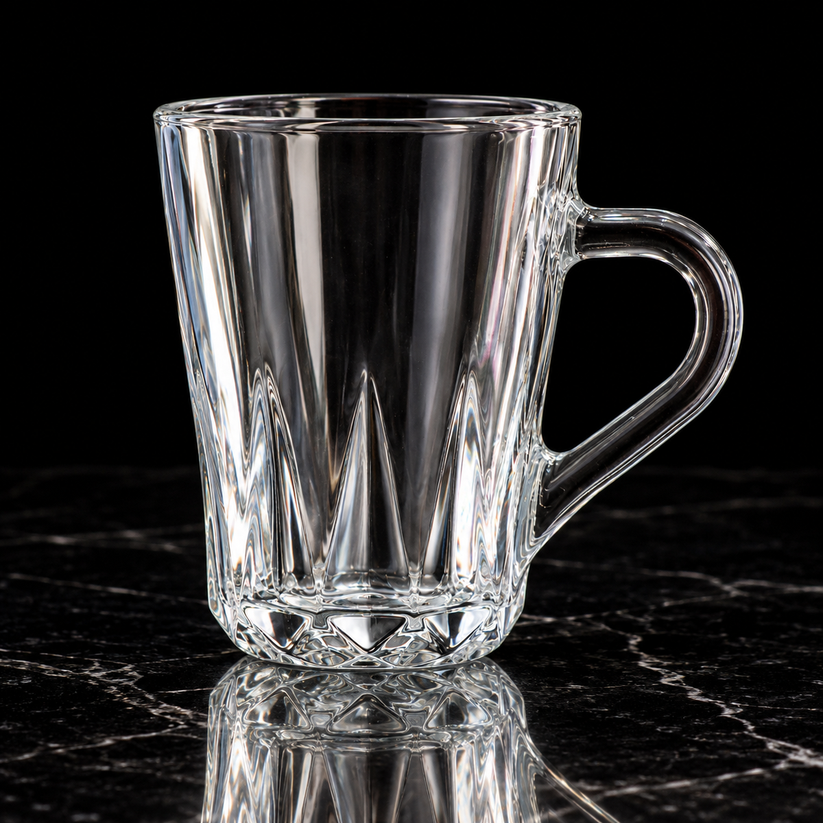 Faceted glass mug on black marble