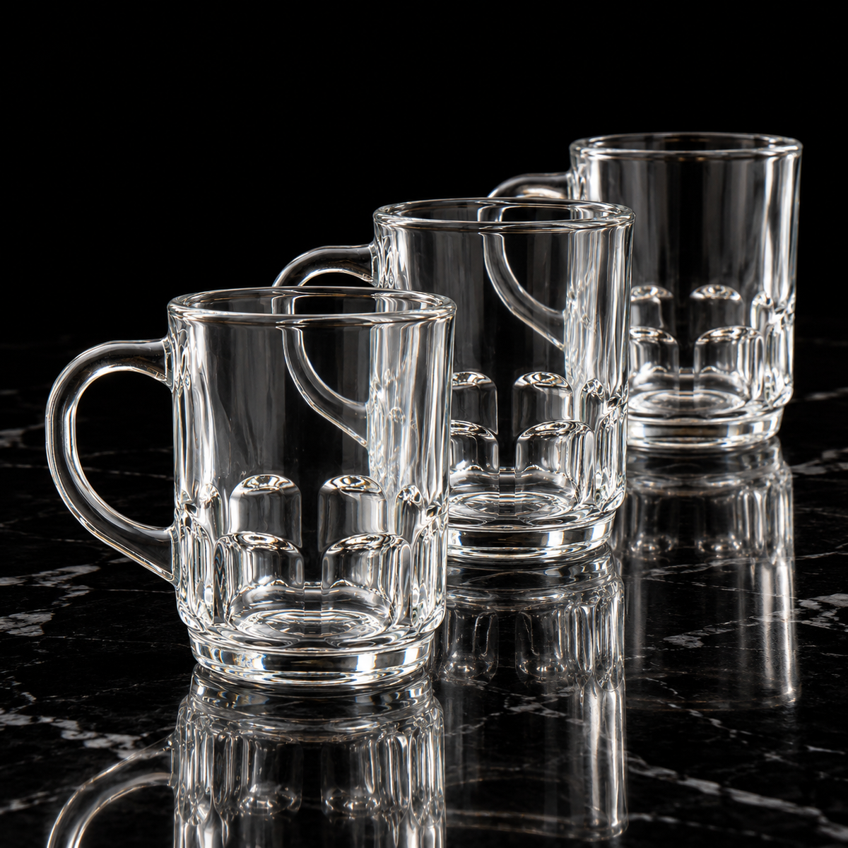 Clear glass mug with dimpled base on black marble