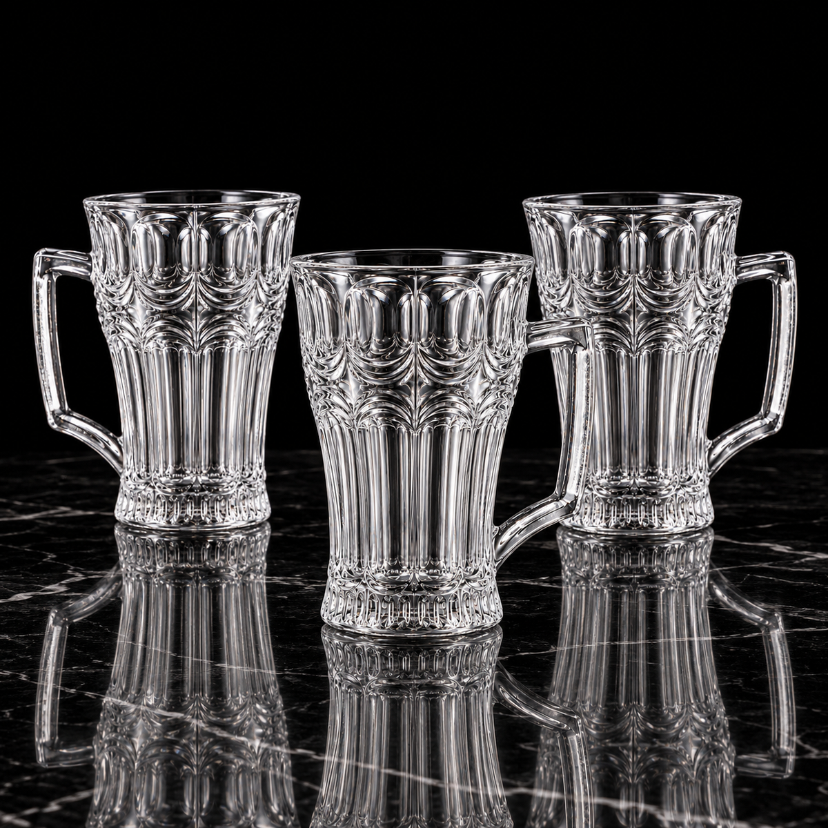 Arch cut glass tea mugs on black marble