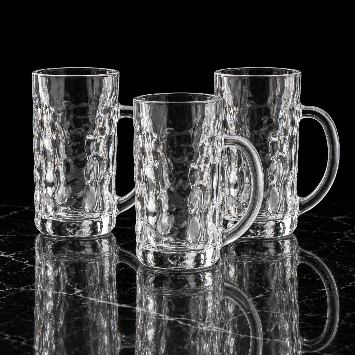 Hammered glass mugs on black marble