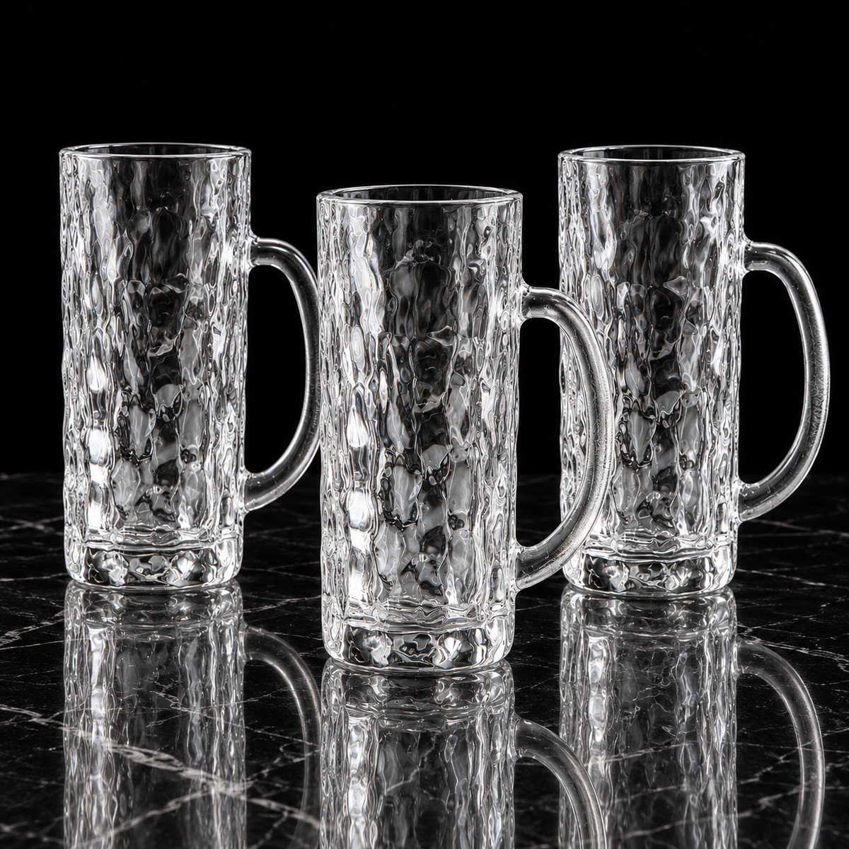 Tall hammered glass mugs on black marble