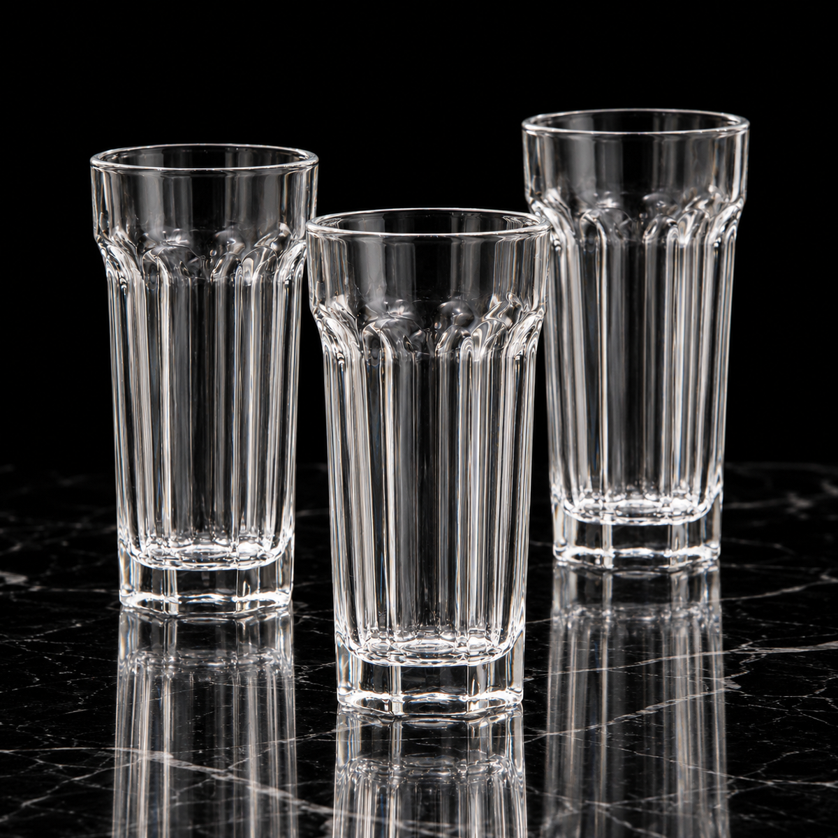 Paneled crystal highball glass on black marble