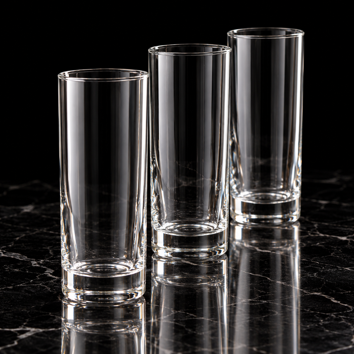 Clear tall highball glass on black marble